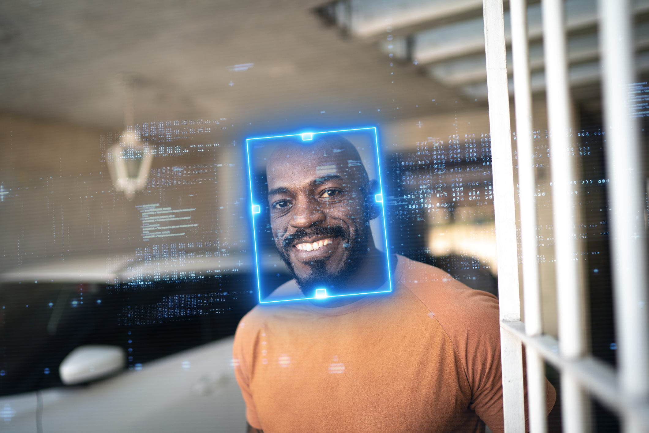 Smiling man identified by facial recognition technology at home garage